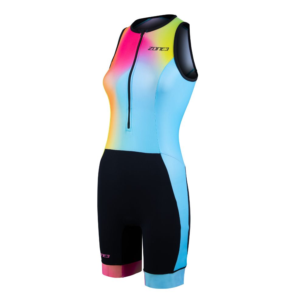 Vista frontal de un trisuit de triatlón sin mangas, con diseño degradado en rosa, amarillo y azul. Cuenta con la parte inferior en negro y cremallera frontal.
