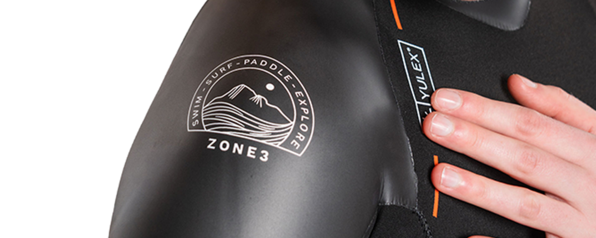 Zone3 wetsuit with branding and a hand touching the material