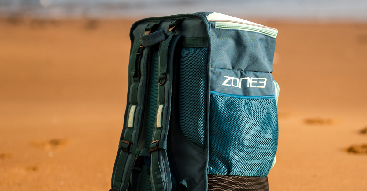 A teal Zone3 Award Winning Transition Backpack bag at the beach