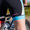 Ciclista con el trisuit de ZONE3. Primer plano de la zona de la pierna, mostrando el logotipo rosa de ZONE3 y la banda degradada azul de la pernera junto al cuadro de la bici.