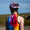 Ciclista con el trisuit Activate+ sin mangas de ZONE3 y casco rosa. El trisuit tiene el logotipo vertical de ZONE3 y un vivo diseño degradado en la espalda.