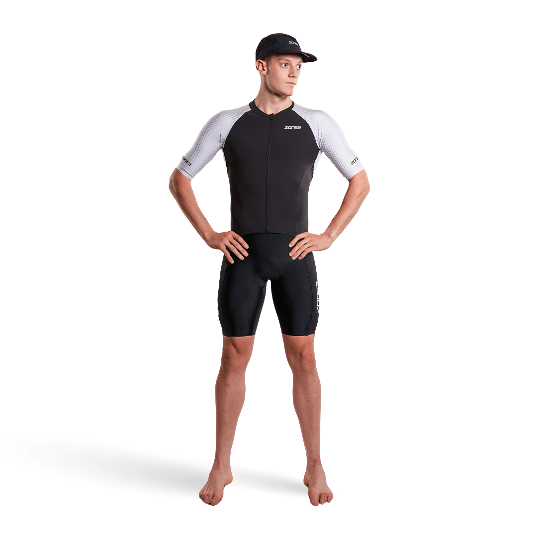 Hombre con el trisuit Lava Long Distance de manga corta y cremallera completa, sobre fondo blanco
