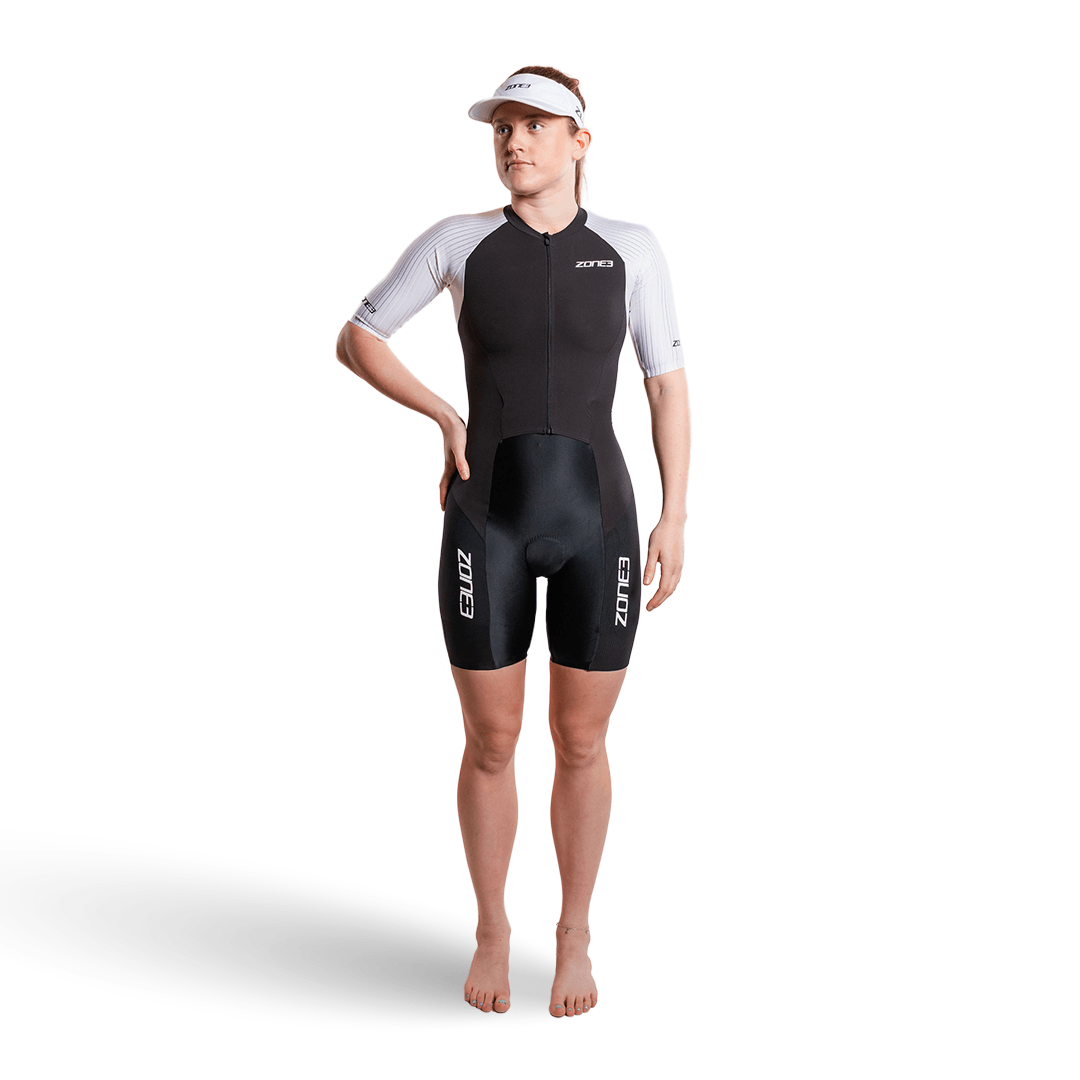 Mujer con el trisuit Lava Long Distance de manga corta y cremallera completa, sobre fondo blanco